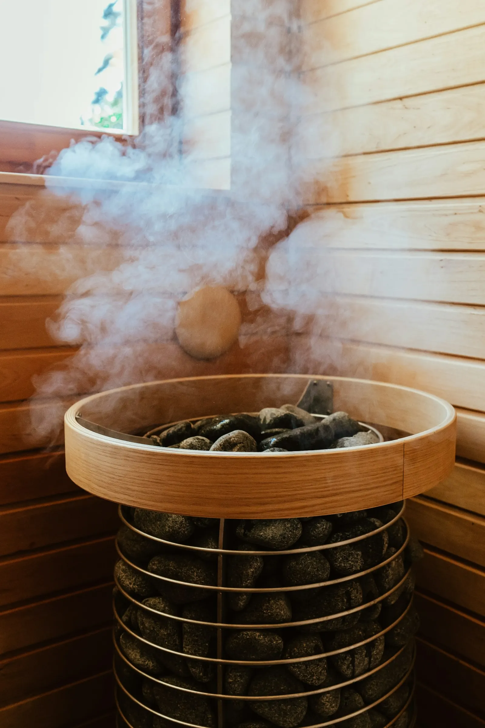 Steam rising from the stones of a Finnish sauna